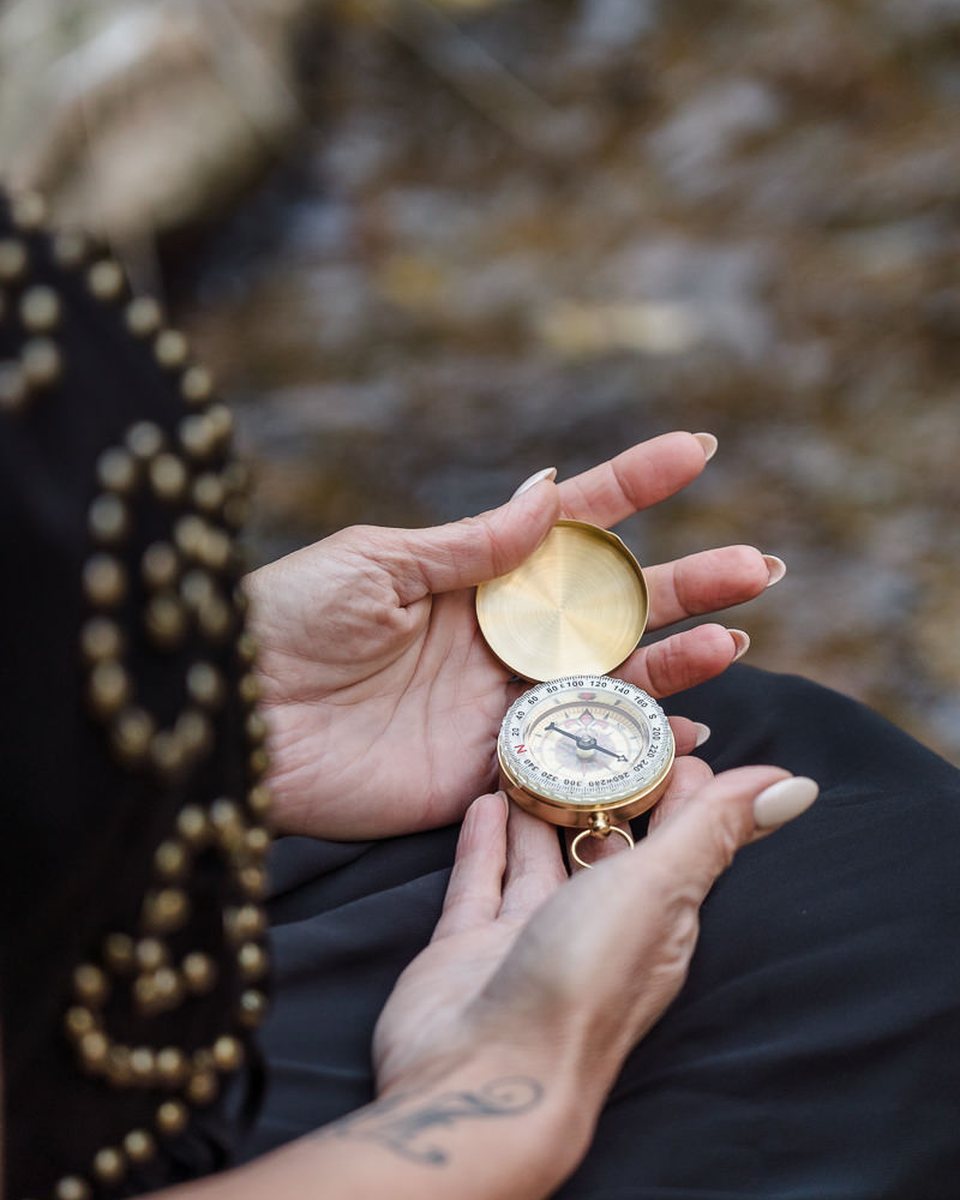 An open compass held in two hands