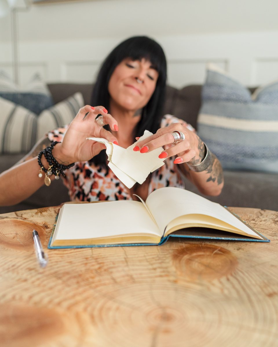 Cristina tearing a page from a journal